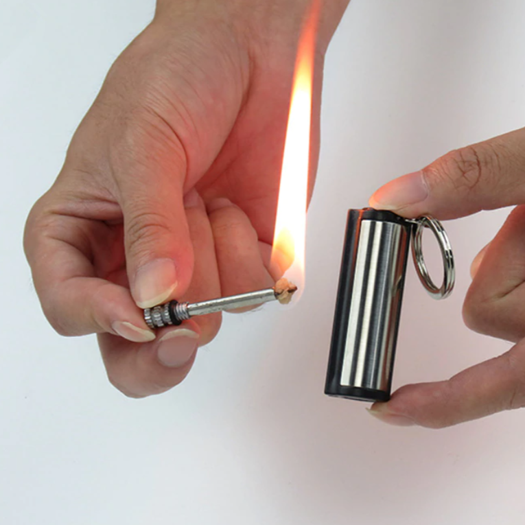 Briquet étanche allumé sur fond noir, résistant au vent