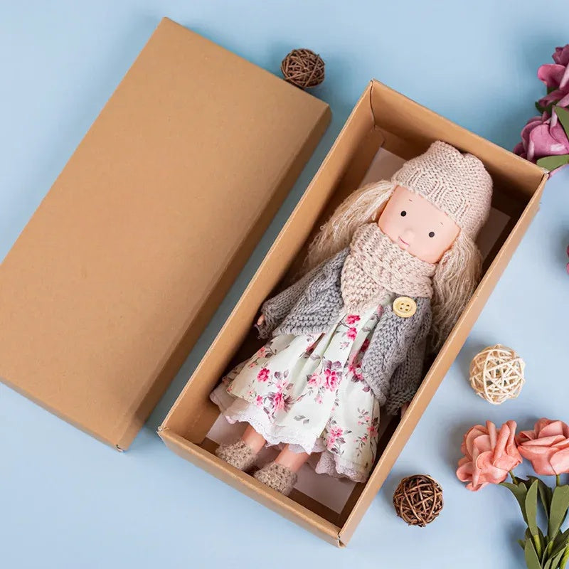 Boîte cadeau ouverte révélant la poupée et accessoires