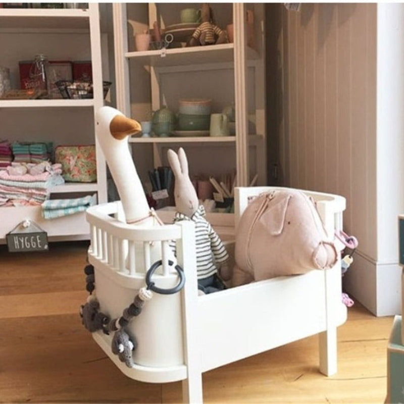 Oie en peluche posée sur une étagère décorative