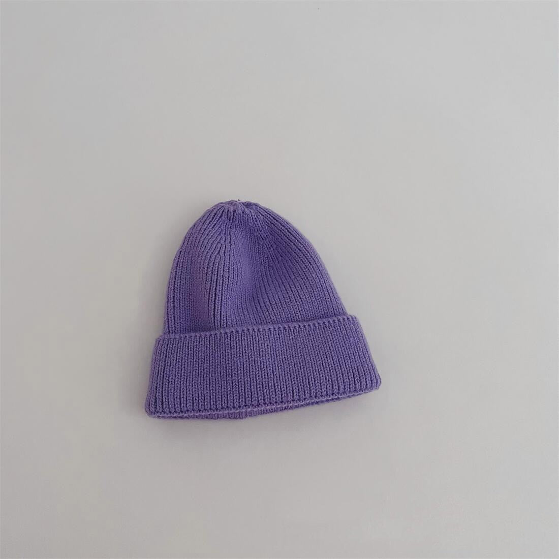 Enfant portant un bonnet jaune en coton, riant