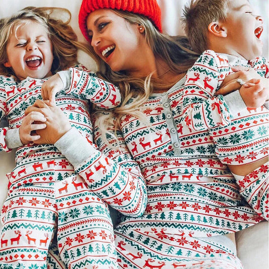 Parents et enfants posant en pyjamas de Noël confortables