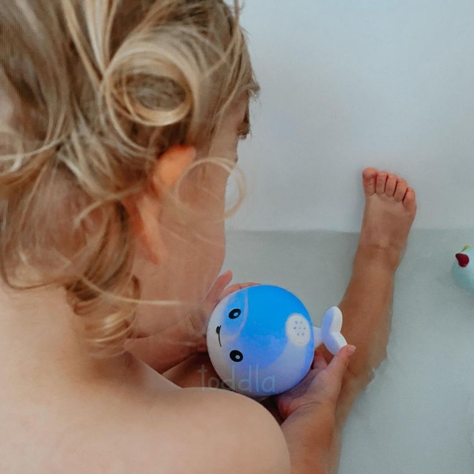 Enfant jouant avec la baleine dans l'eau éclaboussante
