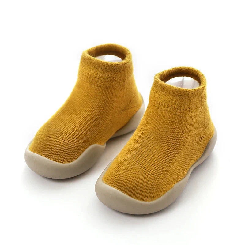 Enfant portant des chaussures à chaussettes, marchant sur tapis