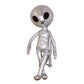 Sac à dos peluche alien posé sur une surface en bois clair