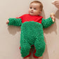 Bébé souriant rampant en combinaison nettoyante sur parquet