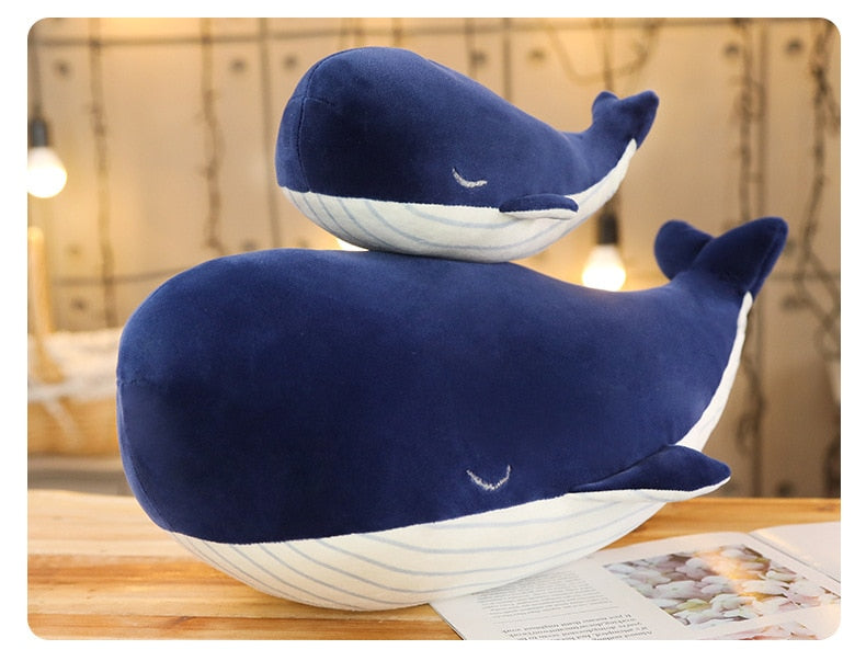 Baleine en peluche posée sur un lit, ambiance cosy