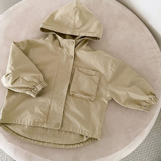 Enfant jouant dehors avec la parka beige et capuche