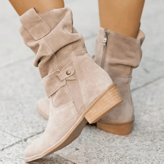 Bottines marron en suède, présentées sur un fond neutre