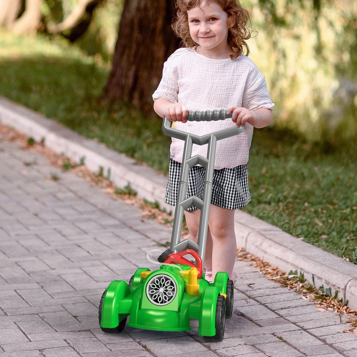 Enfant poussant une tondeuse à bulles dans le jardin