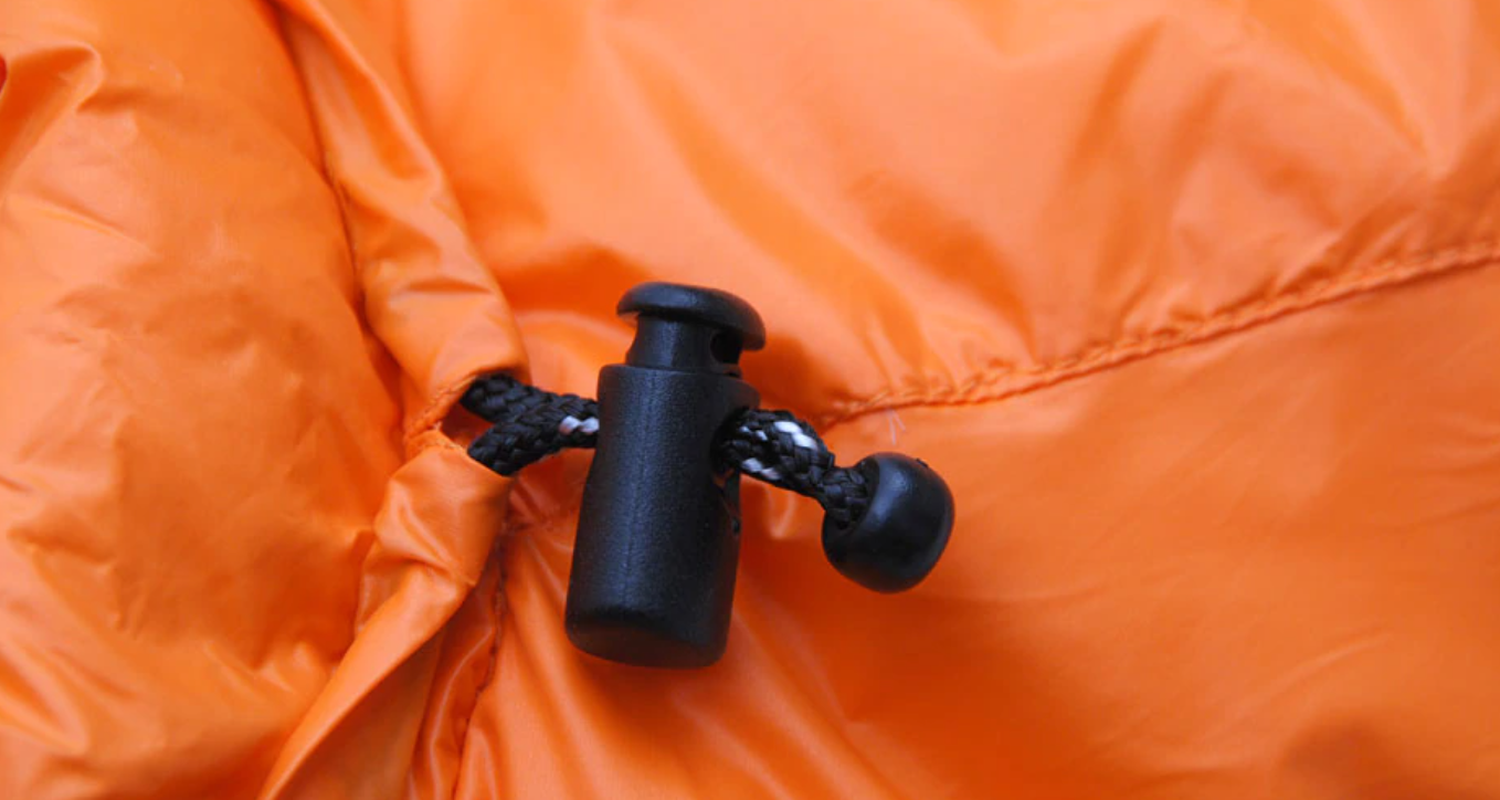 Sac de couchage déplié sur un sol de montagne
