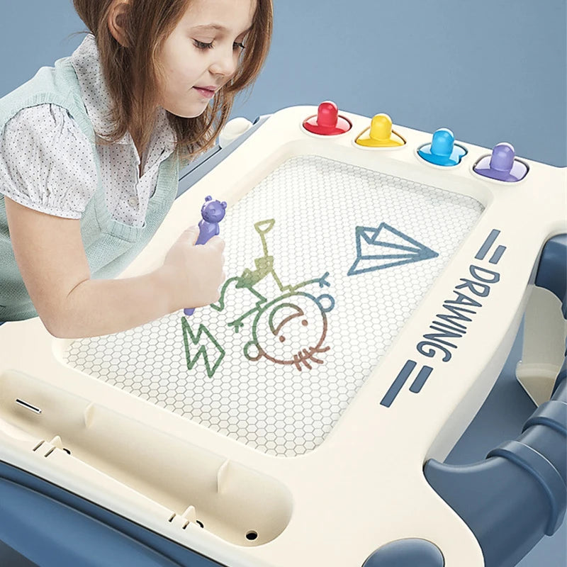 Enfant dessinant sur un tableau magnétique coloré