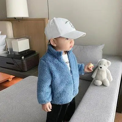 Enfant souriant portant un manteau en peluche, extérieur