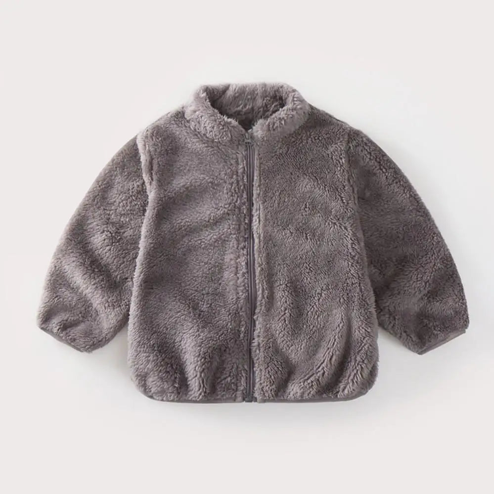 Enfant jouant dehors avec un manteau en peluche