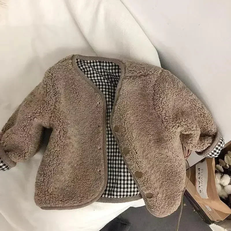 Veste plaid enfant posée sur une surface plane