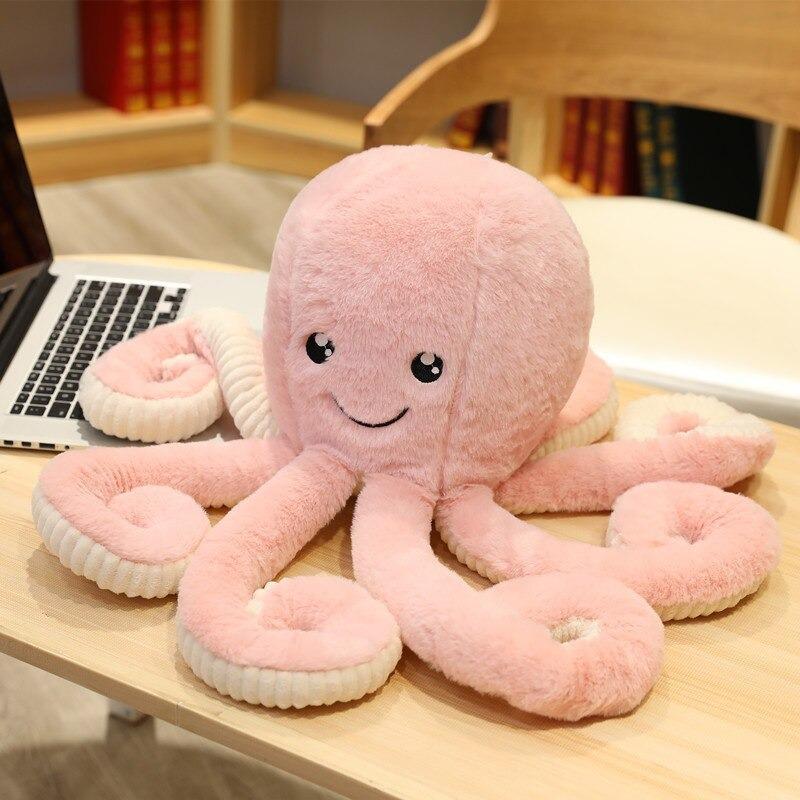 Peluche octopus à côté d'un coussin sur un canapé