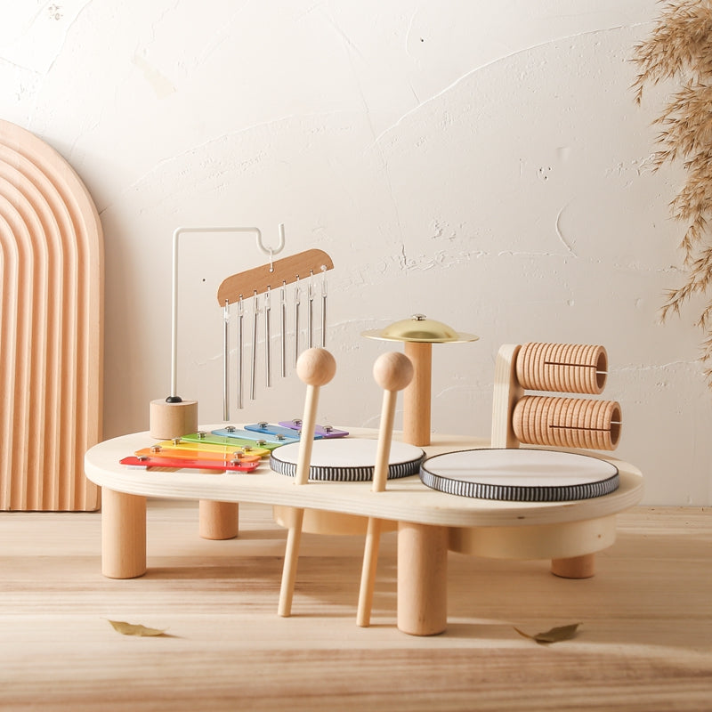 Table musicale en bois montrant xylophone, tambours et hochets