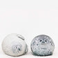 Phoque en peluche posé sur un canapé gris