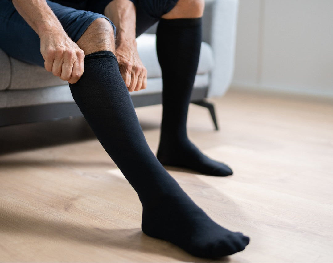 Chaussettes de compression noires sur jambes croisées