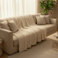 Couverture beige pliée sur lit, ambiance cosy