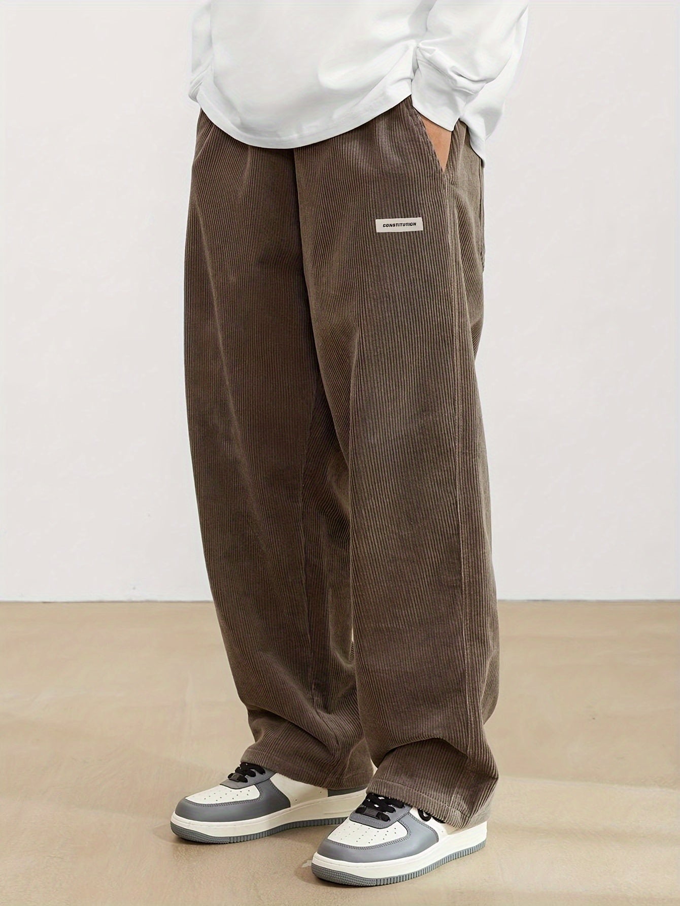 Vue latérale du pantalon en velours côtelé gris clair, jambe large