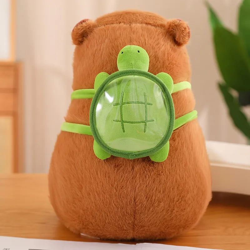 Capybara en peluche assis, montrant le sac à dos tortue