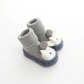 Vue de côté des chaussures en peluche grises pour bébé