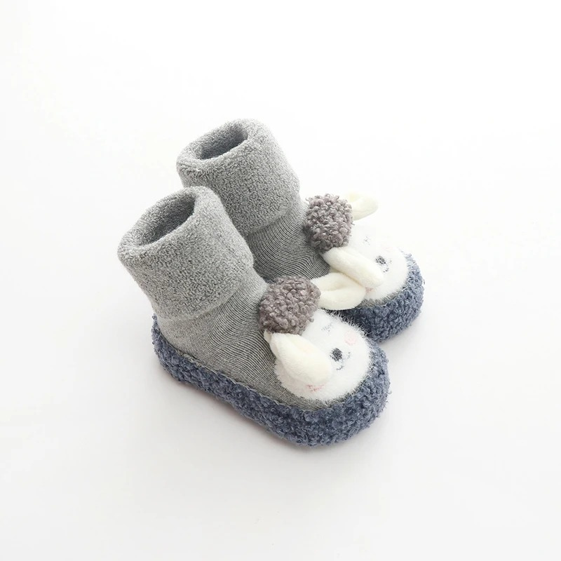 Vue de côté des chaussures en peluche grises pour bébé