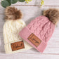 Bonnet avec pompon, couleur neutre, posé sur table