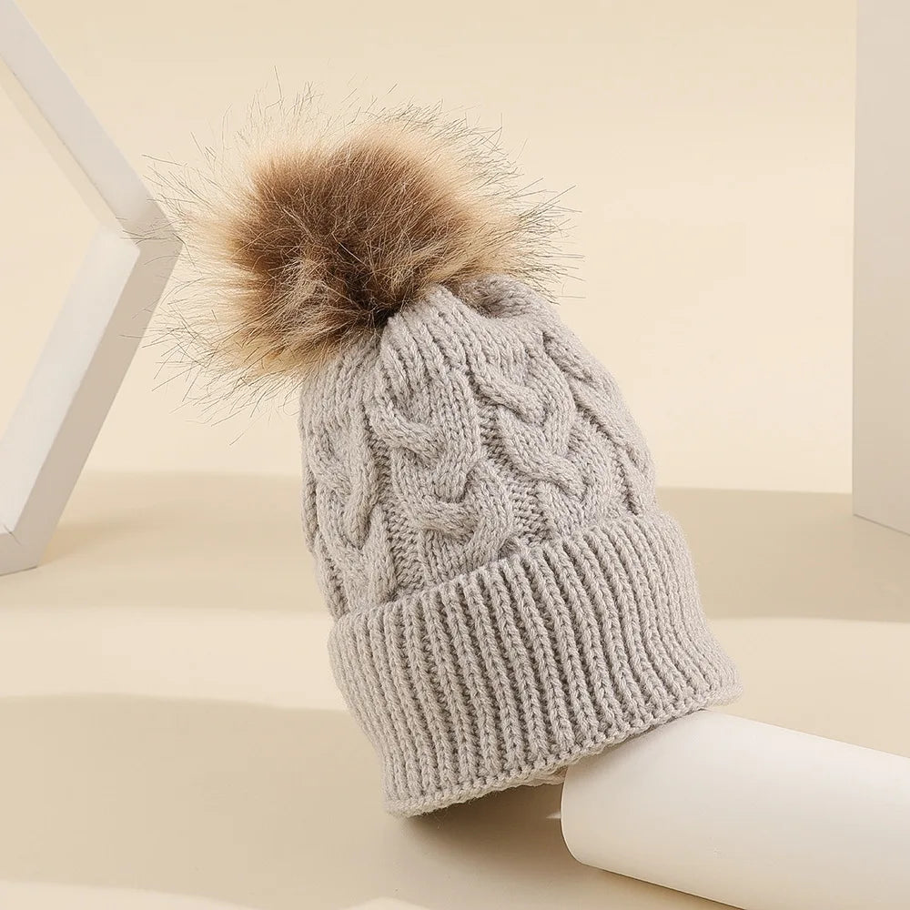 Bonnet d'hiver avec pompon, présenté sur fond uni