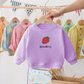 Pull imprimé fraises, présenté sur un mannequin