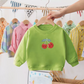 Pull cerise porté avec un jean, style décontracté