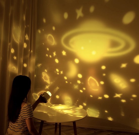 Enfant endormi sous un ciel étoilé projeté par l'appareil