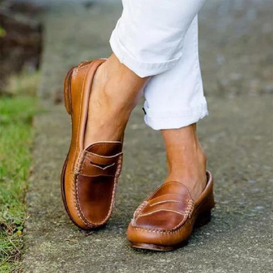 Mocassins classiques posés sur une surface en bois clair