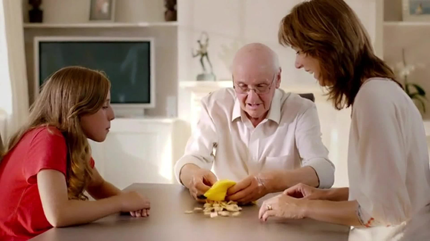 Famille souriante en train de jouer, concentrée sur le plateau