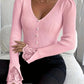 Gros plan sur les boutons effet perle du pull