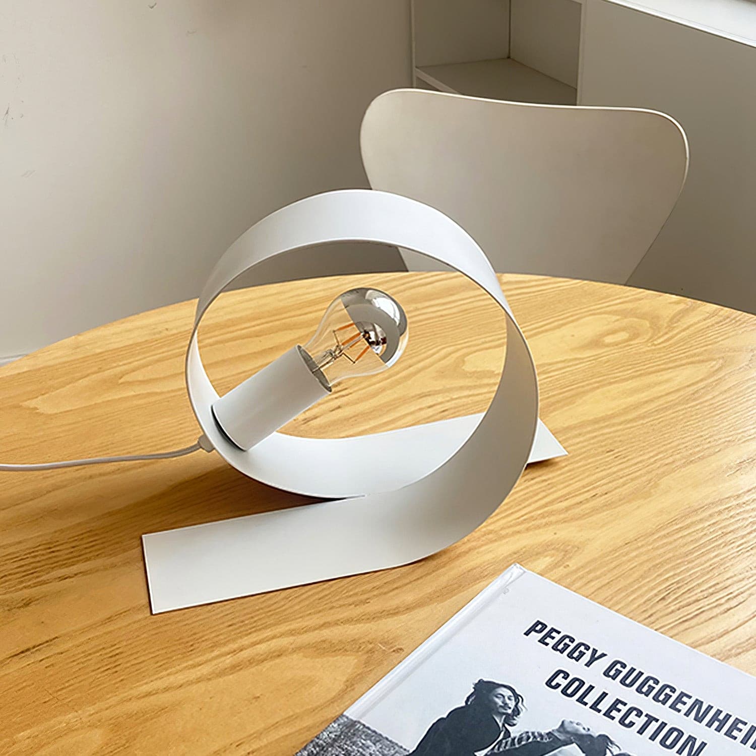 Lampe de table minimaliste en métal blanc sur fond neutre