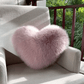 Coussin cœur moelleux posé sur une chaise en bois