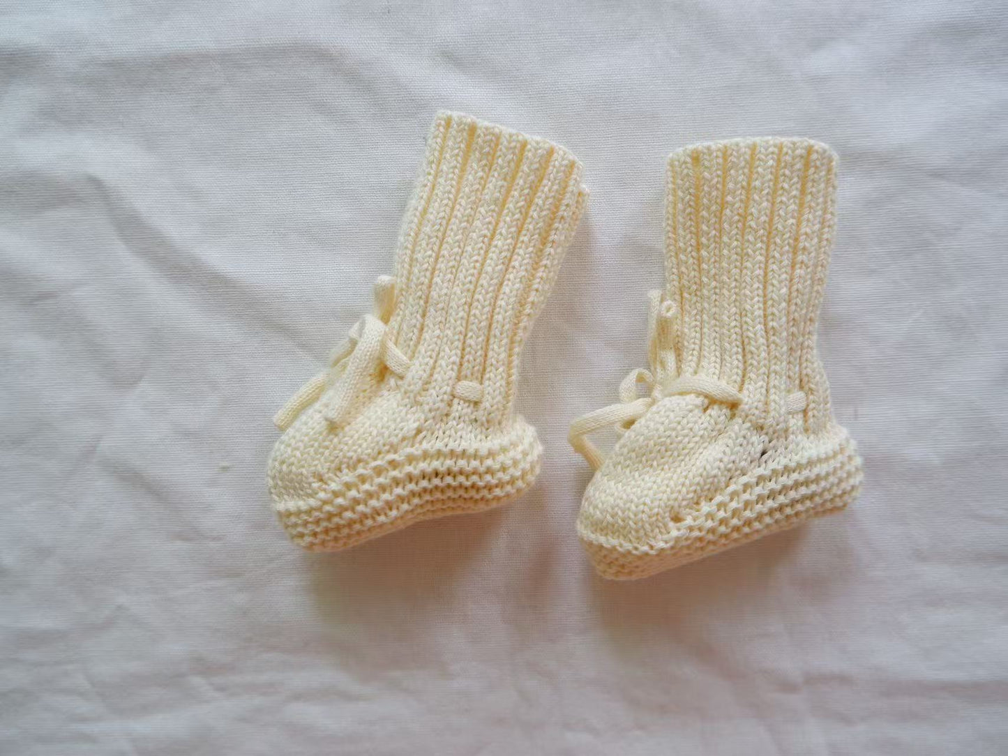 Chaussons tricotés pour bébé sur fond de bois naturel