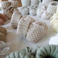 Chaussons bébé en tricot gris posés sur une couverture