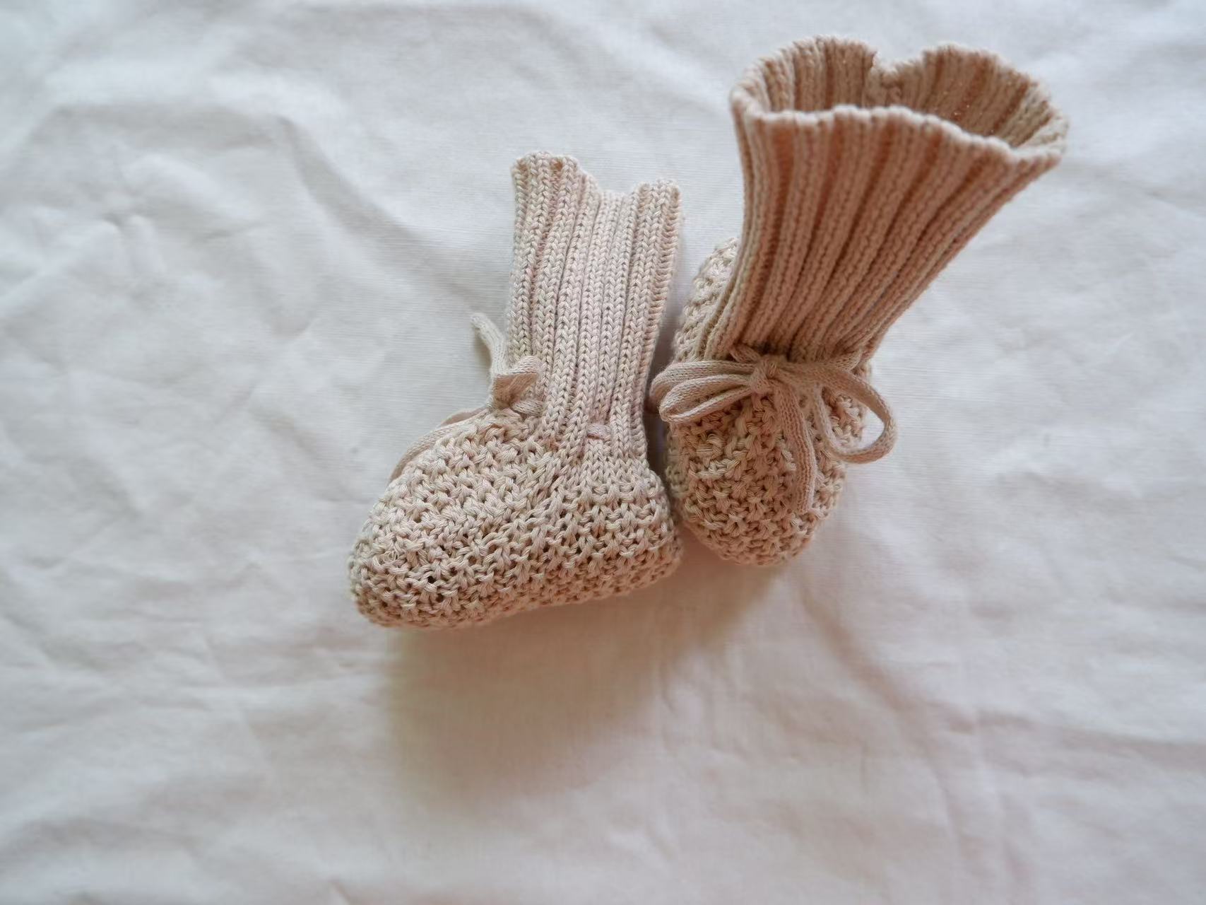 Chaussons en tricot rose pour bébé sur fond blanc