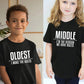 Enfants souriants en t-shirts assortis, jouant dans le jardin