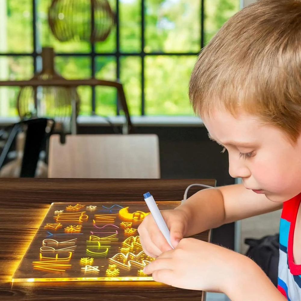 Enfant dessinant sur une tablette LED lumineuse