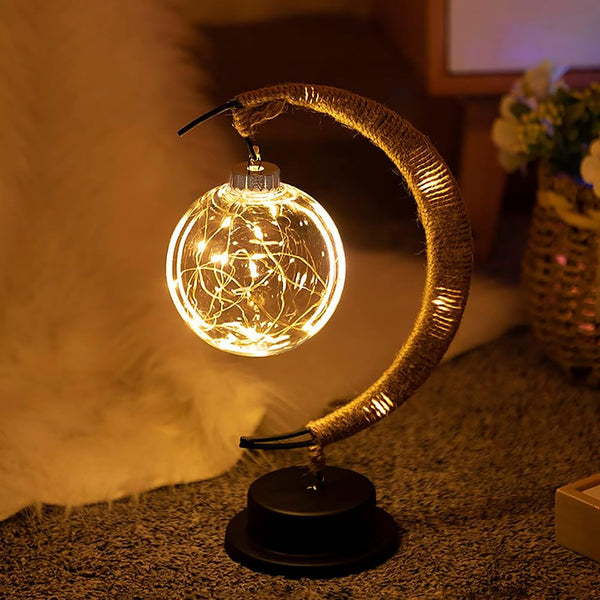 Lampe lunaire en verre allumée sur une table en bois