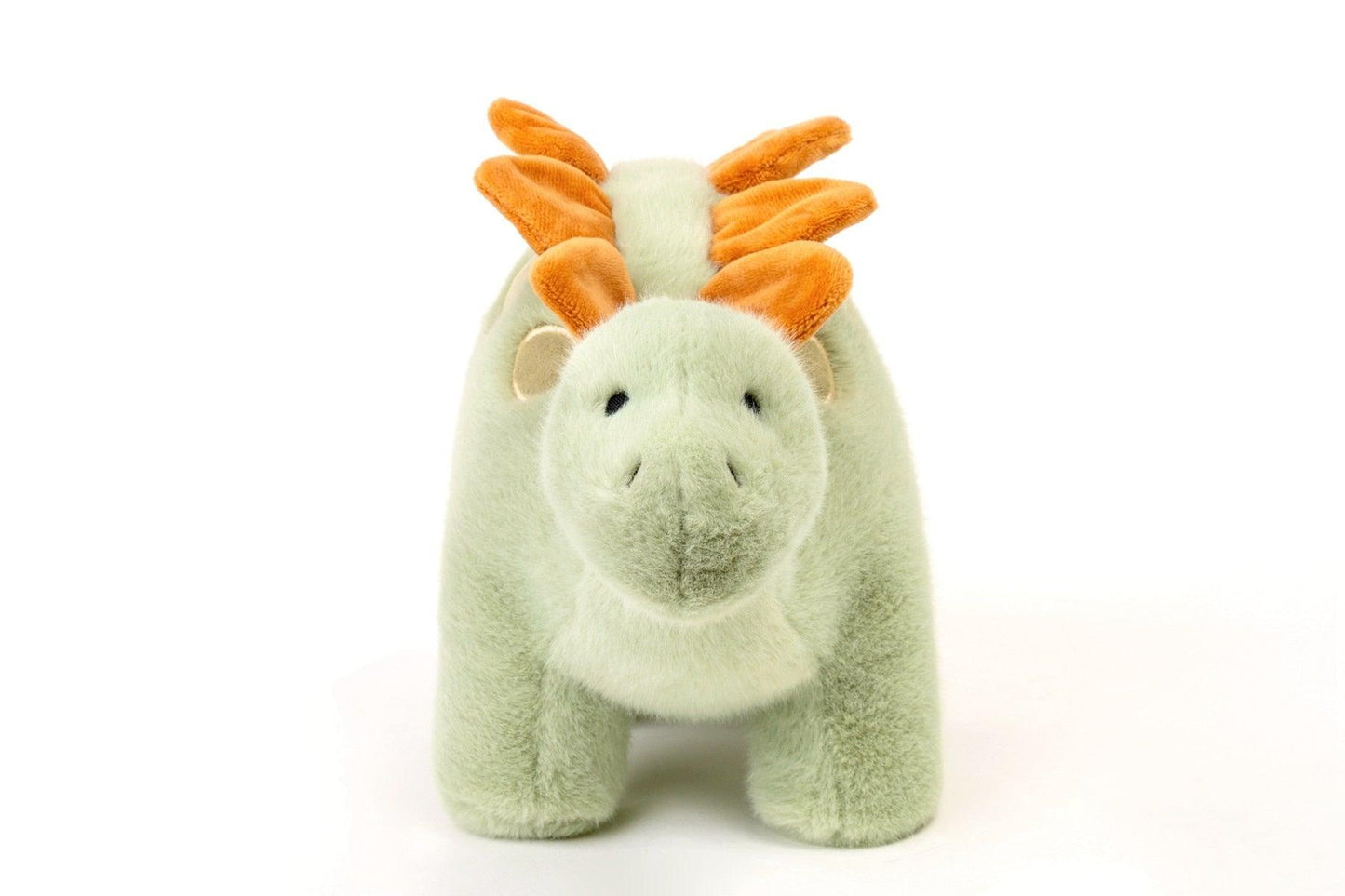 Gros plan sur le visage amical du dinosaure en peluche