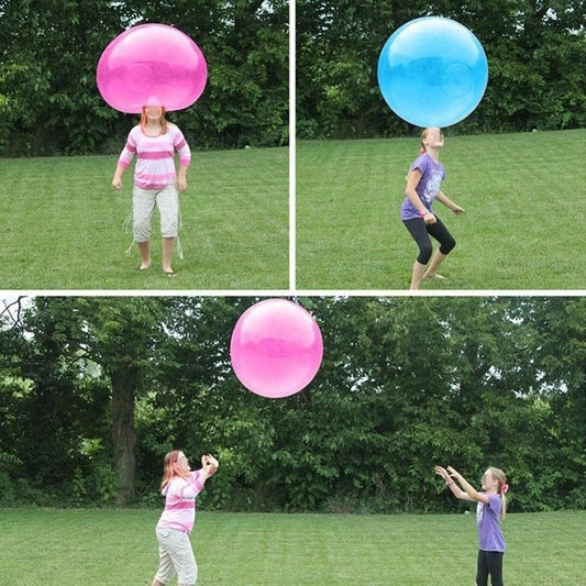 Enfant jouant avec un ballon géant rouge en extérieur