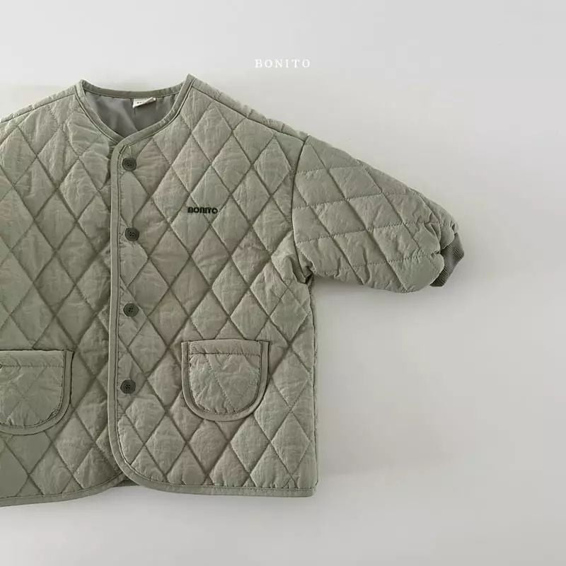 Gros plan sur la texture matelassée de la veste verte