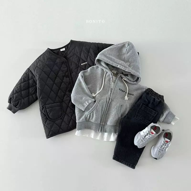 Enfant portant une veste matelassée beige en extérieur