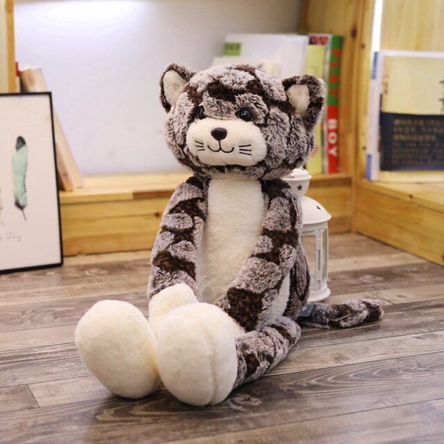 Chat en peluche Kawaii entouré de coussins colorés