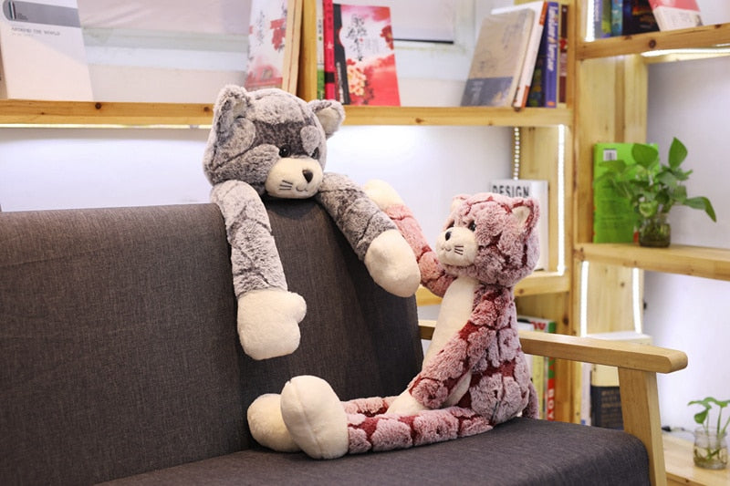 Chat en peluche Kawaii posé sur une étagère en bois