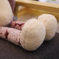 Trois peluches chats Kawaii alignées sur un canapé